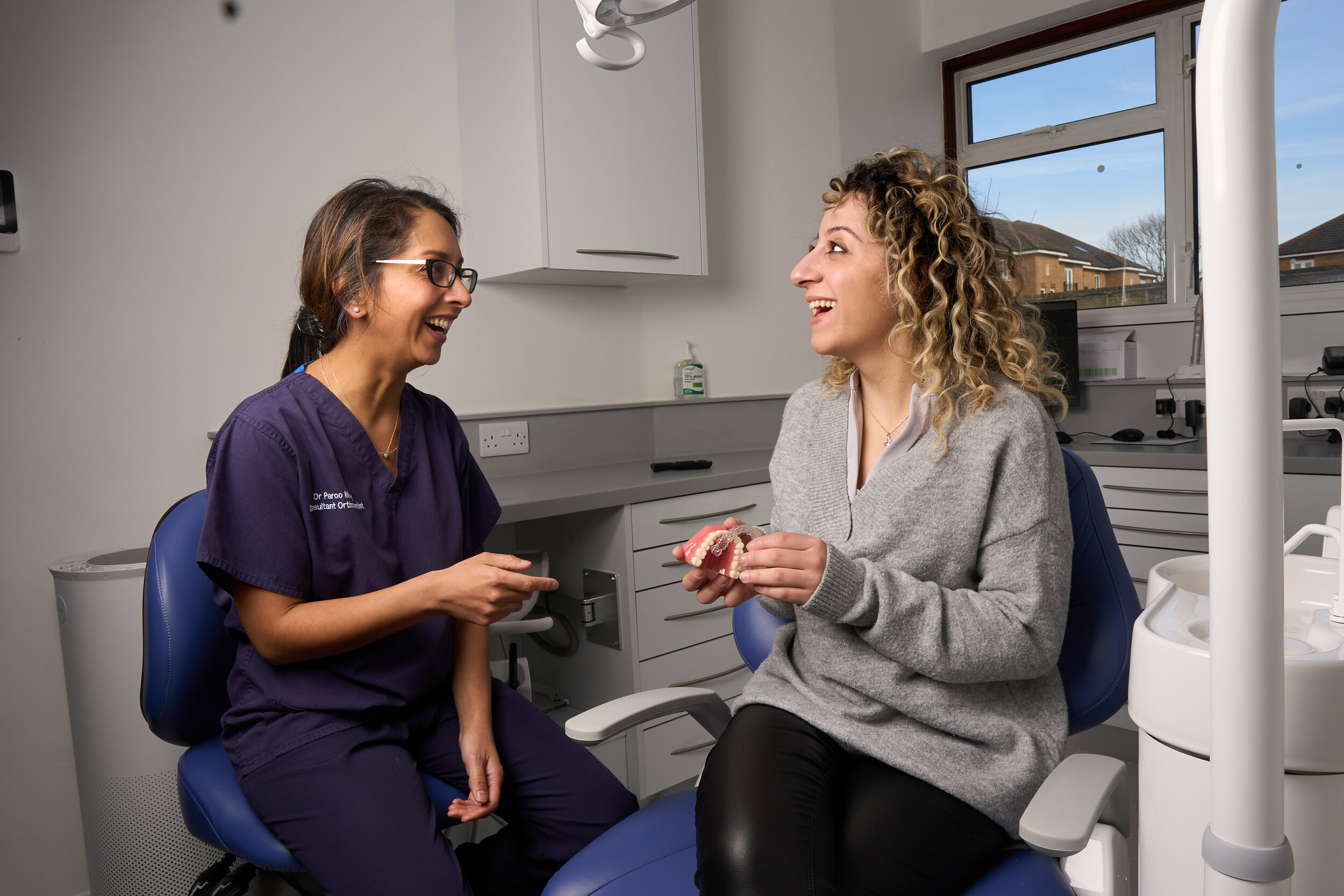 Dr Paroo Mistry, Consultant Orthodontist, talking a patient through clear aligners