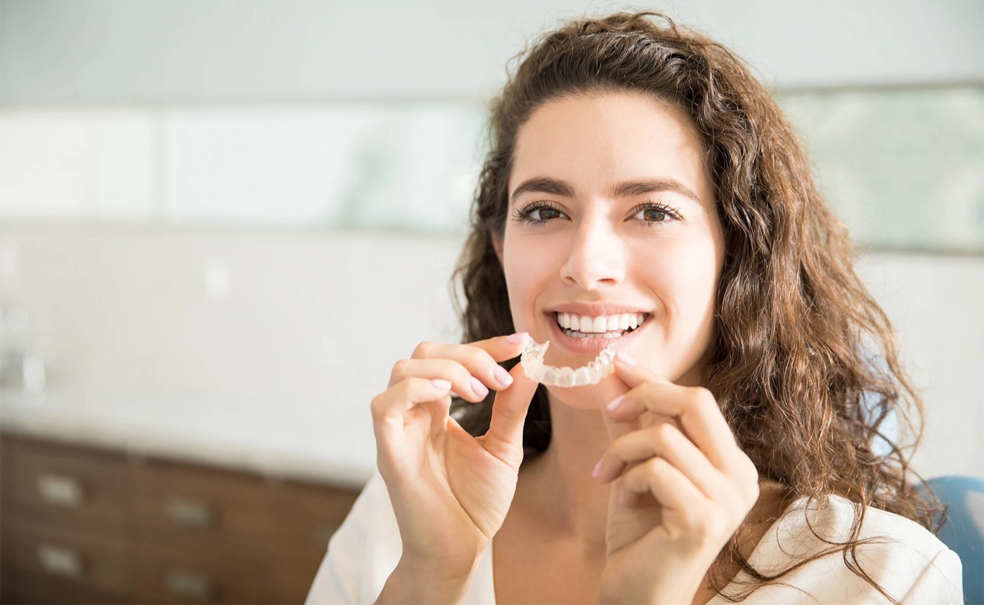 Patient holding an Invisalign clear aligner